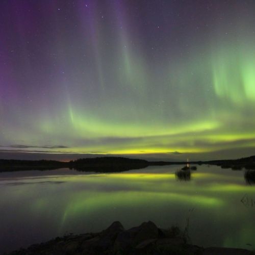 Revontulia Vassorin Kyrkfaretin eli kirkkoväylän yllä. Taivaanrannassa näkyvät Tiondholmen-, Likören- ja Sandören-saaret. Valokuva: Mikael Herrgård.